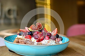Restaurant dessert.  Sweet breakfast.Egg toast with fruits on top. Figs, raspberries, strawberries, mint,  blueberry fruits