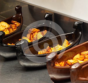 Restaurant dish of boat with fried potatoes in fryer, close-up