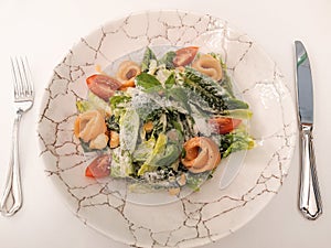 Restaurant dish, Caesar salad with croutons, quail eggs, cherry tomatoes and grilled chicken, top view