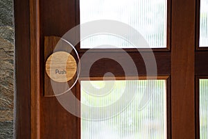 Restaurant door handle with push sign on classic wooden door