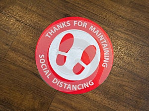 A restaurant floor sign for maintaining social distance.