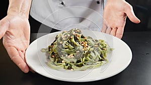 Restaurant food. chef presenting plate with delicious italian pasta in kitchen. Close-up. Restaurant food cooking and