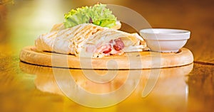 Restaurant food concept. Lavash burrito stuffed meat sausage and cheese sauce served salad. Meat wrapped with lavash