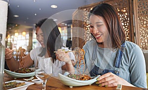 Restaurant, girl friends and smile with food, noodles and cafe happy from bonding. Asian women, eating and plate