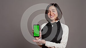 Restaurant hostess presenting smartphone with greenscreen