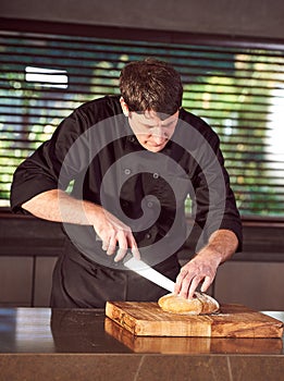 Restaurant hotel private chef slicing fresh loaf of bread