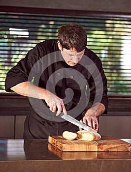 Restaurant hotel private chef slicing fresh loaf of bread