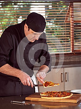 Restaurant hotel private chef slicing home made pizza