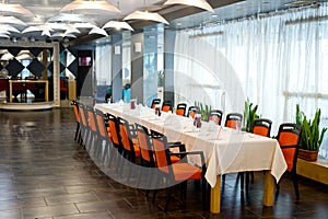 Restaurant interior with a served table and large windows overlooking the river