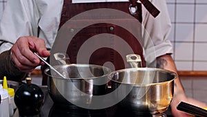 Restaurant kitchen - the chef making sauce for the meal with meat