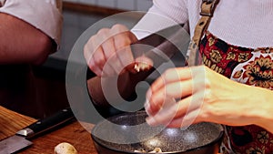 Restaurant kitchen - the chef peeling off the mushrooms with a sharpened knife