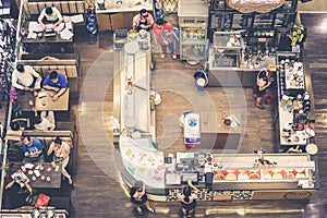 Restaurant with kitchen and people sitting at tables seen from above