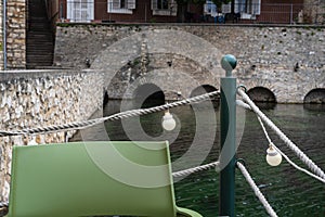 restaurant by the lake, chair back, rope railing, green support post