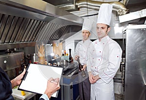 Restaurant manager briefing to his kitchen staff in the commercial kitchen