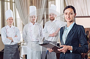 Restaurant manager and his staff in kitchen. interacting to head chef in commercial kitchen