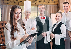 Restaurant manager and his staff in kitchen. interacting to head chef in commercial kitchen.