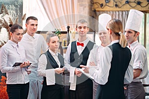 Restaurant manager and his staff in kitchen. interacting to head chef in commercial kitchen.