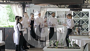 Restaurant manager and his staff in terrace. Interacting to head chef in restaurant