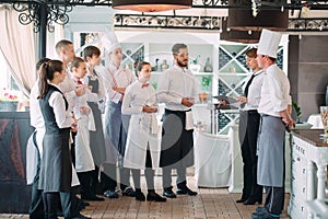 Restaurant manager and his staff in terrace. interacting to head chef in restaurant.
