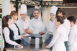 Restaurant manager and his staff in terrace. interacting to head chef in restaurant.