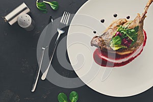 Restaurant meals. Duck confit with vegetables on black backgroun