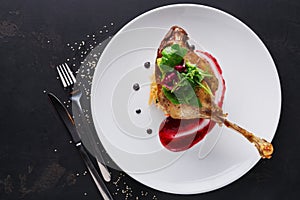 Restaurant meals. Duck confit with vegetables on black background