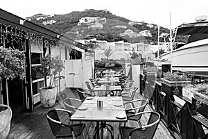 Restaurant open air in philipsburg, sint maarten. Terrace with tables, chairs and yacht in sea. Eating and dining