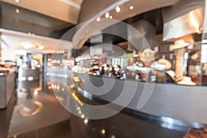 Restaurant open kitchen blur background in luxury hotel showing chef cooking over blurry food counter for buffet catering service photo