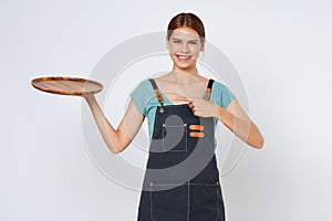 Restaurant owner sme woman holding empty plate or dish and pointing isolated on white background