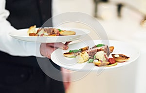 Restaurant, plates and waiter serving food for fine dining, luxury meal and classy date for valentines day. Hospitality