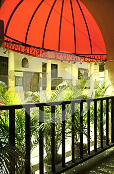 A restaurant with red roofage and green plants