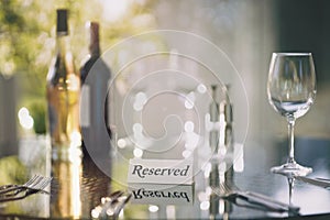 Restaurant reserved table sign with place setting and wine glasses ready for a party