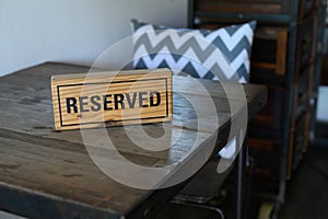 Restaurant reserved table sign Reserved Table. A tag of reservation placed on the wood table