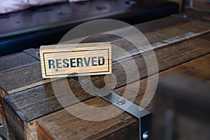 Restaurant reserved table sign Reserved Table. A tag of reservation placed on the wood table