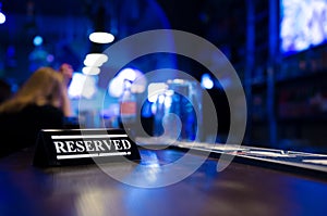 Restaurant reserved table sign standing on wooden table in bar