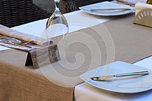 Restaurant reserved table sign with wineglasses and plates