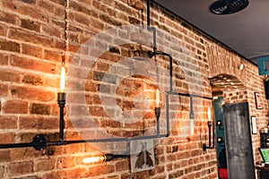 Restaurant rustic walls, vintage interior design lamps, metal pipes and light bulbs