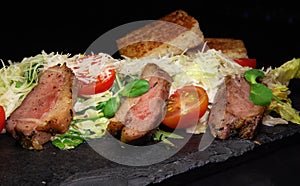 Restaurant serving snacks on the board - fried bread, meat, finely chopped cheese, tomatoes and greens.