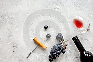 Restaurant set with wine bottle and grape on stone top view mock
