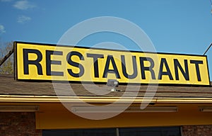 Restaurant Sign Outdoors On Building Roof With Blue Sky