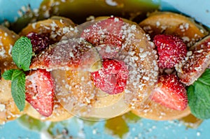 Restaurant sweet breakfast. Small pancakes with caramel cream and strawberries, figs, raspberries, fruit and meant on top.