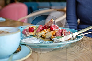 Restaurant sweet breakfast. Small pancakes with caramel cream and strawberries, figs, raspberries fruit and mint on top.