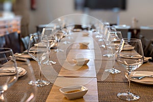 Restaurant table for multiple diners with glasses and cutlery and olive oil