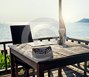 Restaurant table, with reserved sign at beach sea view
