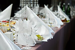 Restaurant table setting decor with glasses for wine. Different meals for the guests.