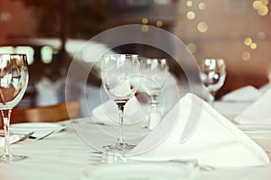 Restaurant table setting with wine glass. Selective focus on wine glass