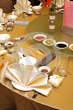 A restaurant table setup of utensils and flower decorations