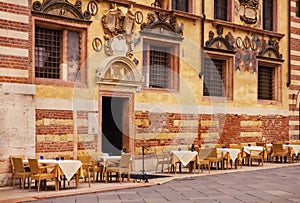 Restaurant tables in front of Palazzo Ragione in Piazza dei Signori in Verona
