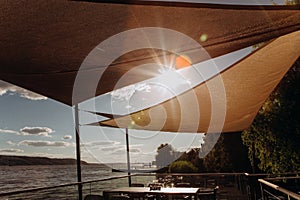 Restaurant terrace seashore ray sun through awning photo
