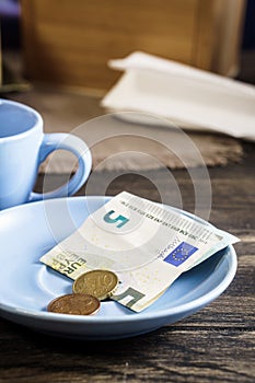 Restaurant tips in euro banknotes and coins